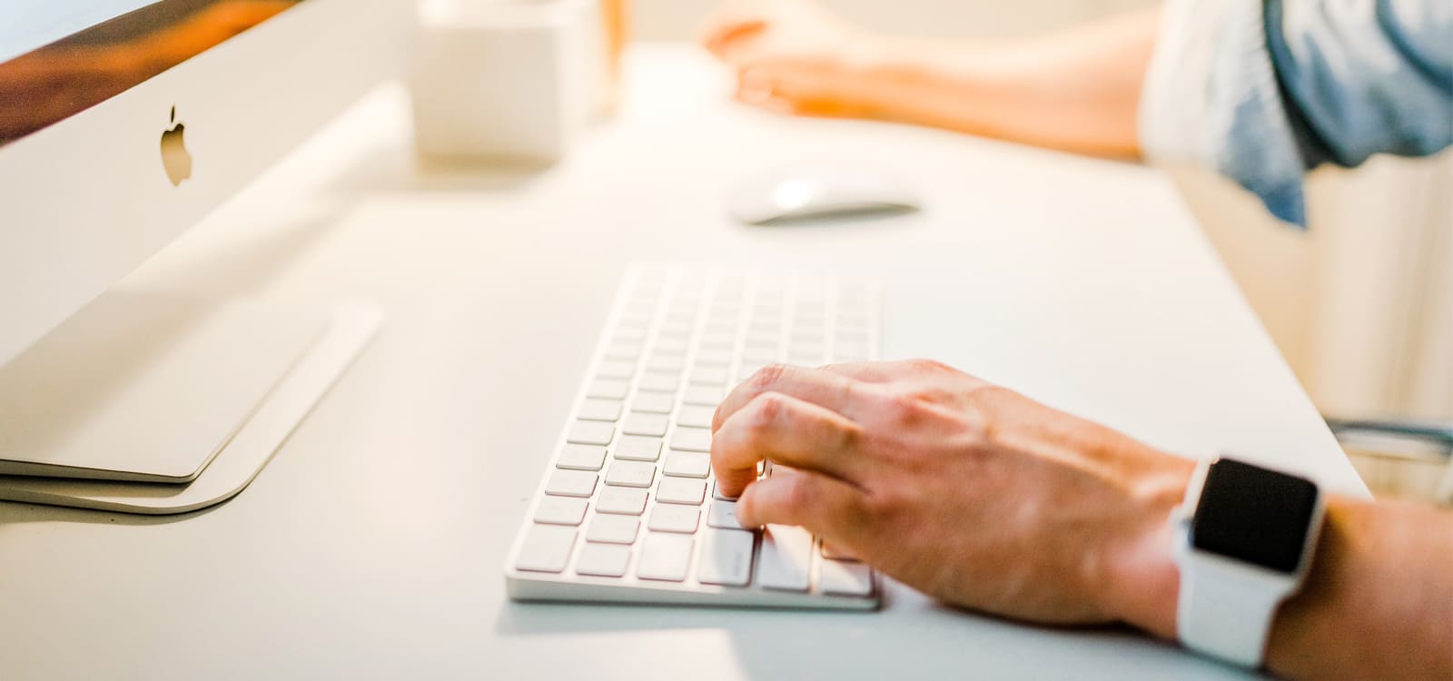 person typing on Apple computer keyboard